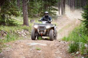 quad being riden on mountain dirt road